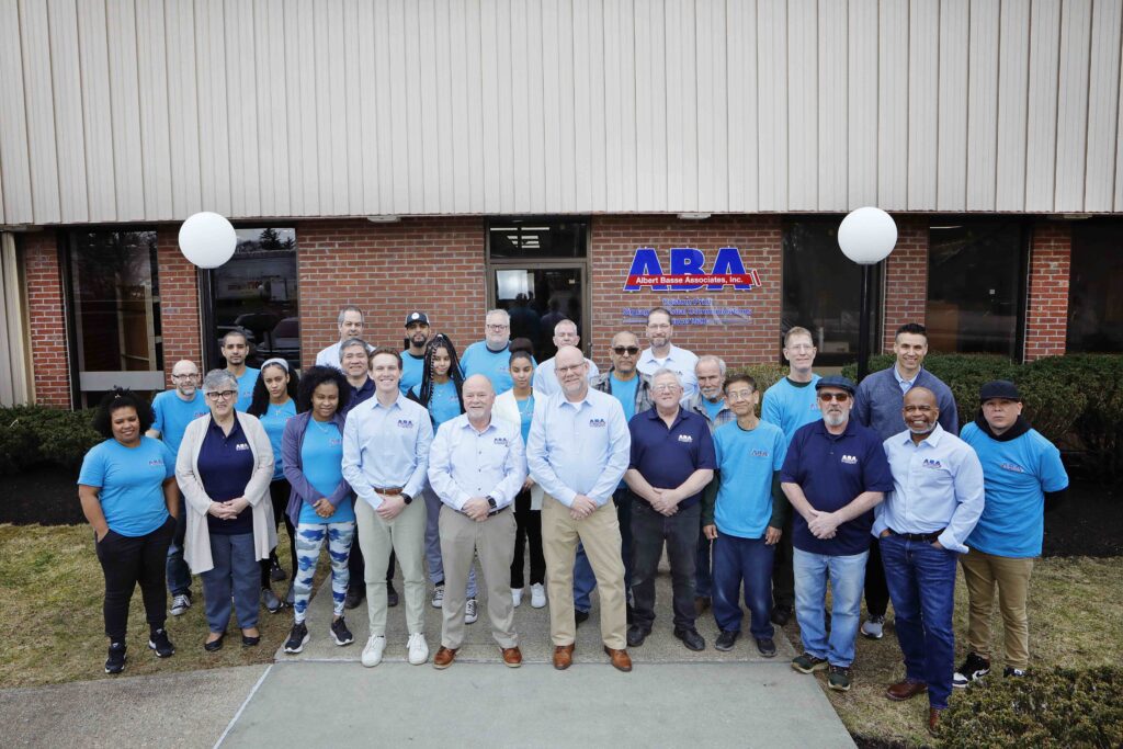 image shows a group of people in front of a building with the logo of "ABA Albert Basse Associates, Inc.".