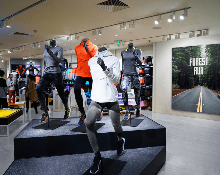 image displays a retail store, likely a sports or athletic wear store, featuring several mannequins showcasing running apparel and footwear