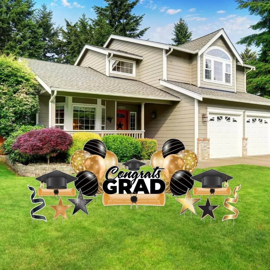 image displays a "Congrats Grad" yard decoration set, likely intended for celebrating a graduation, placed on a lawn in front of a house